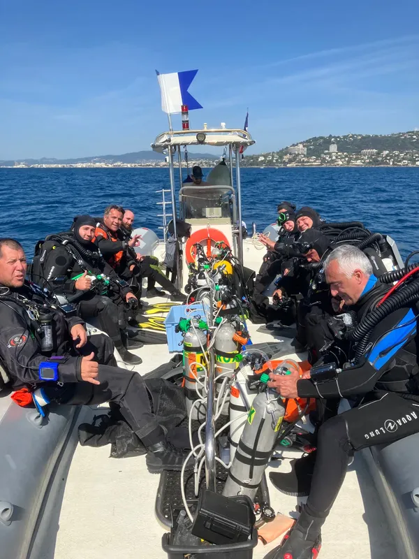 Plongeurs équipés sur un bateau semi-rigide en mer, direction site