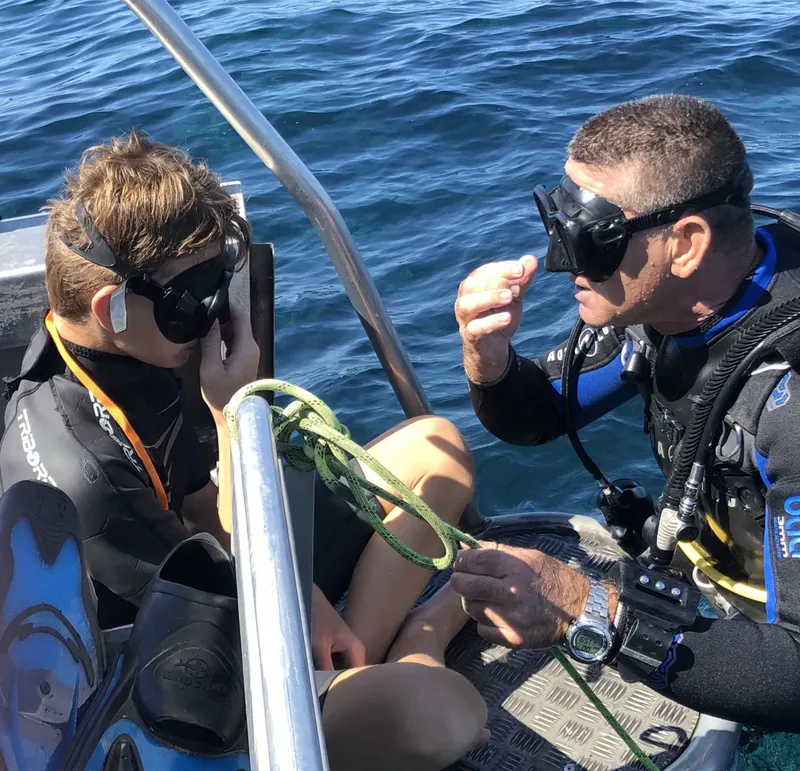 Deux plongeurs discutent à bord d'un bateau en mer