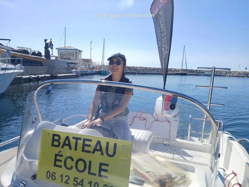 Femme souriante à bord d'un bateau école dans un port ensoleillé