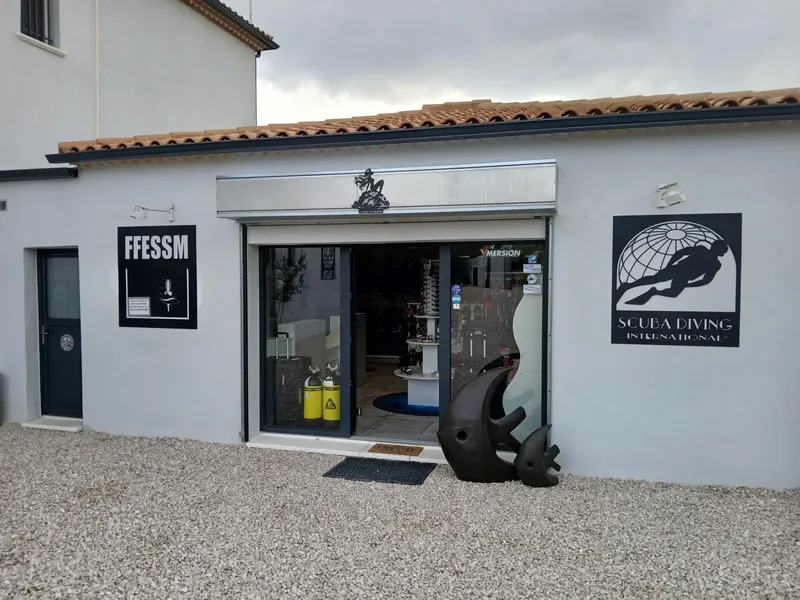 Façade d'un centre de plongée avec enseignes et équipement visible