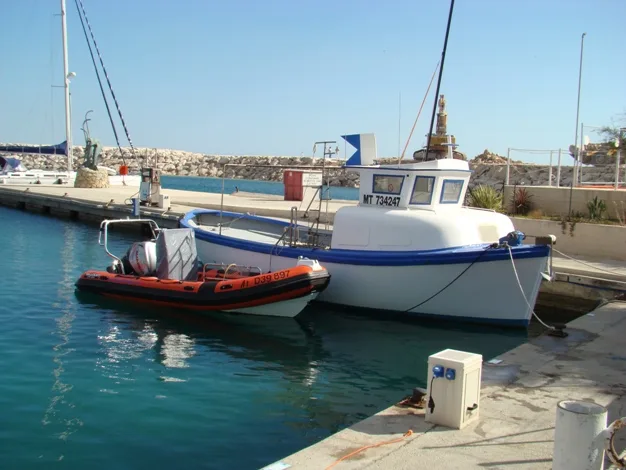 Deux bateaux amarrés dans un port ensoleillé, vue sur le quai