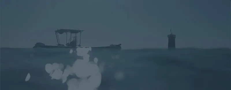 Bateau de plongée sur une mer sombre avec une tour au loin