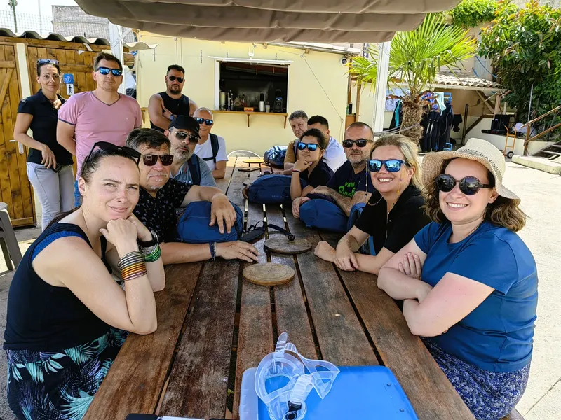 Groupe de personnes souriantes assis à une table devant un comptoir