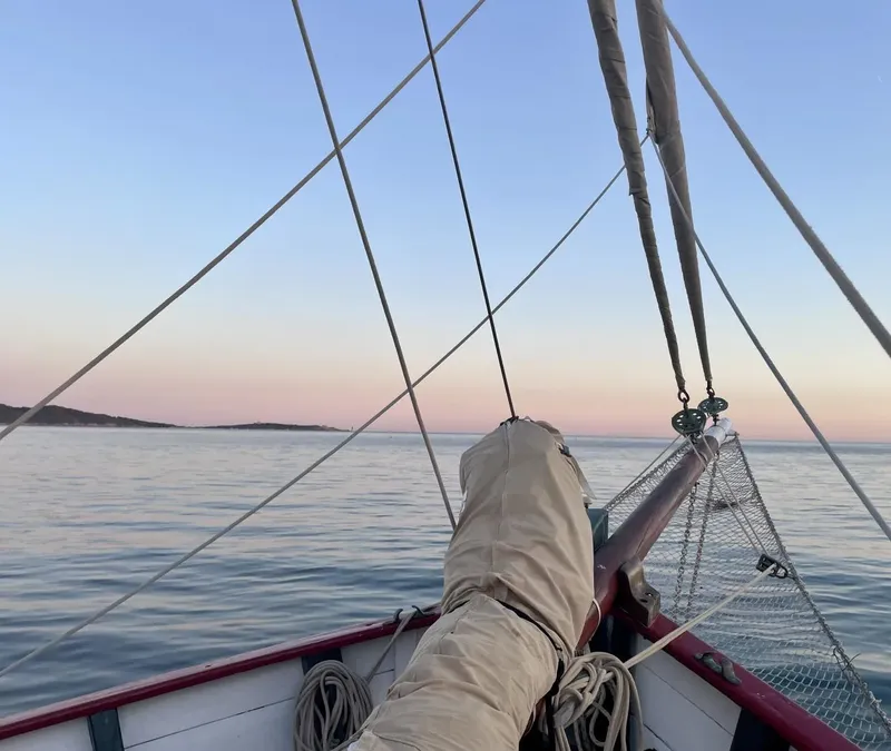 Vue depuis un bateau en mer, jambes d'une personne reposant sur l'avant