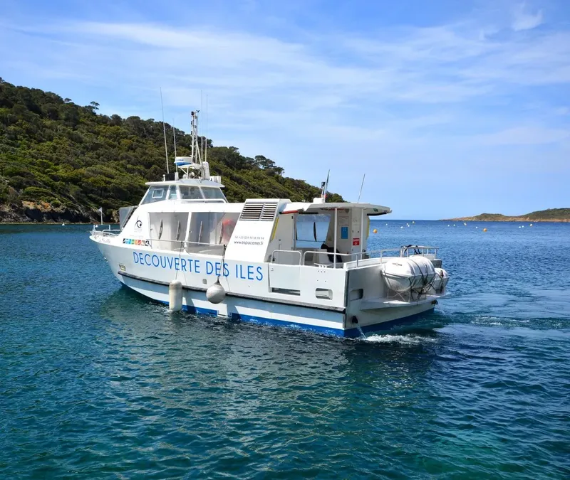 Bateau blanc et bleu sur l'eau, avec texte 'Decouverte des Iles'