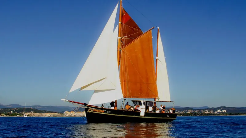 Voilier traditionnel avec des passagers naviguant sur une mer bleue calme
