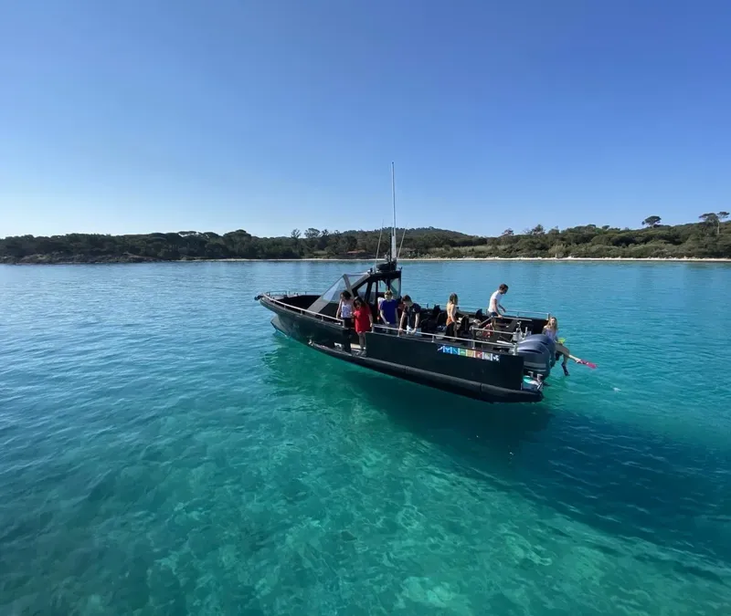 Bateau pneumatique avec passagers naviguant sur une eau turquoise claire