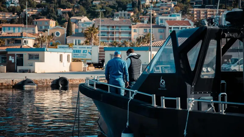 Deux personnes observent le port depuis un bateau noir amarré