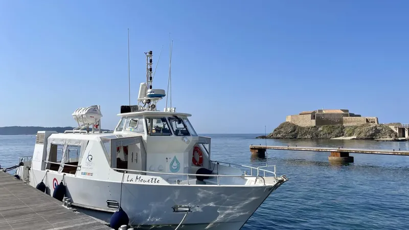 Bateau de plongée amarré au port avec une forteresse en arrière-plan