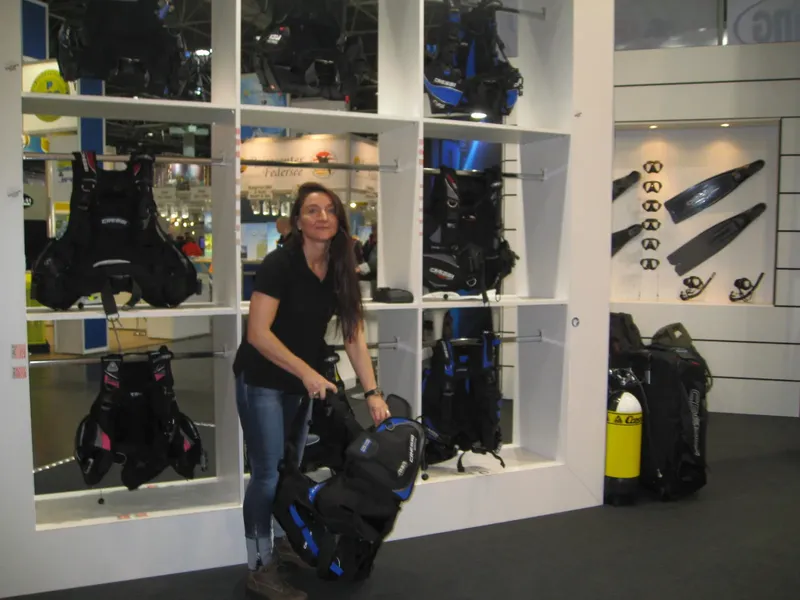 Femme dans un magasin de plongée entourée de matériel et d'équipements