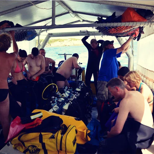 Plongeurs se preparant a bord d'un bateau, equipement visible, ambiance conviviale