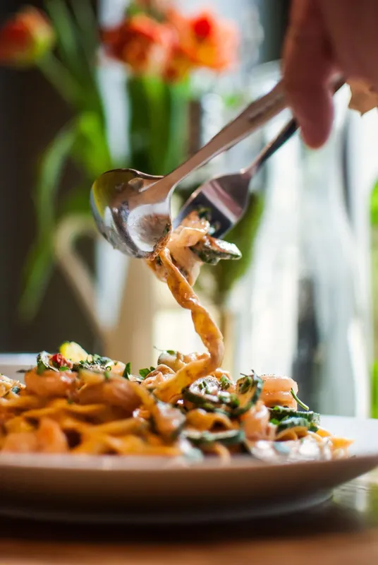 Des pâtes à la sauce crémeuse sont enroulées sur une fourchette