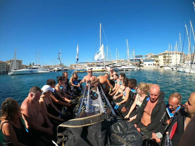 Groupe de plongeurs sur un bateau pneumatique dans un port ensoleillé