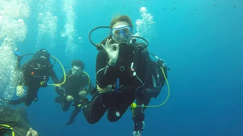 Plongeuses souriantes sous l'eau, communication gestuelle, exploration marine