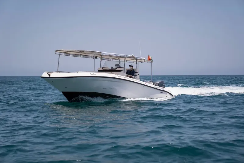 Bateau de plongée blanc navigue sur une mer calme et bleue