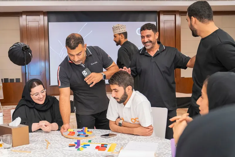 Groupe de personnes discutant autour d'une table avec des objets colorés