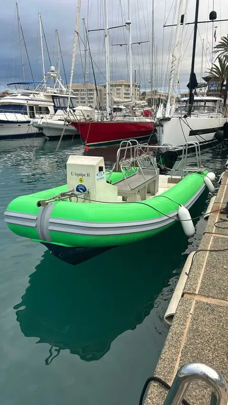 Bateau de plongée vert fluo amarré dans un port ensoleillé