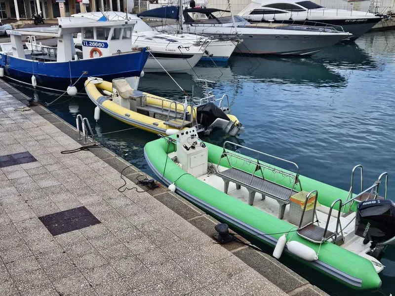 Plusieurs bateaux amarrés dans un port ensoleillé, vue sur l'eau