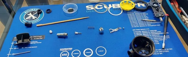 Pièces détachées d'un détendeur de plongée disposées sur une surface bleue