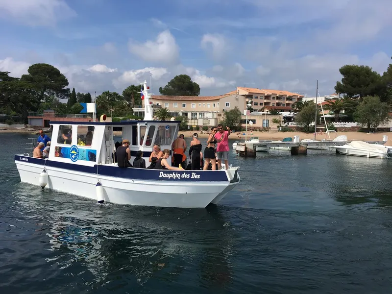 Bateau de plongée amarré avec des personnes à bord en journée ensoleillée