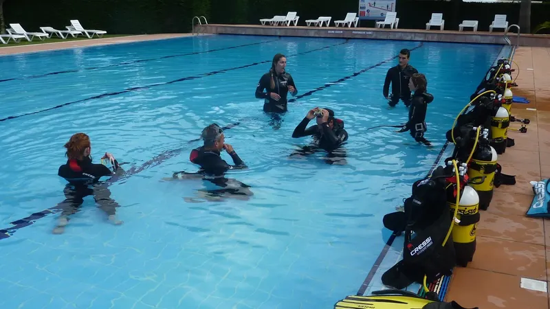 Cours de plongée en piscine avec plusieurs participants équipés