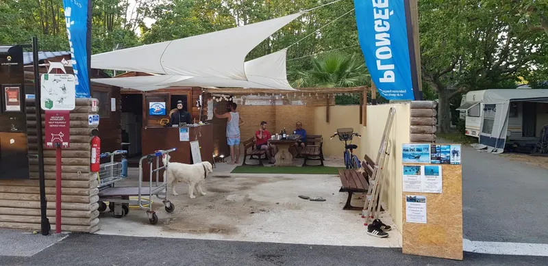 Terrasse d'un centre avec des personnes assises et un chien