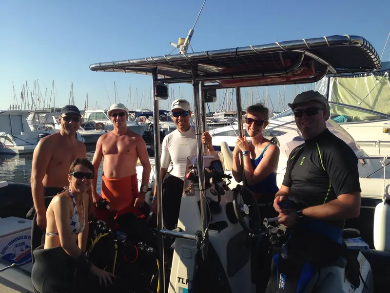 Groupe de personnes souriantes sur un bateau de plongée ensoleillé