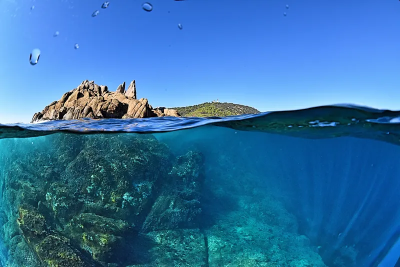 Paysage sous-marin avec rochers et île au loin ciel bleu
