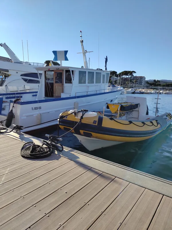 Bateaux amarrés sur un ponton en bois, mer calme, ciel bleu