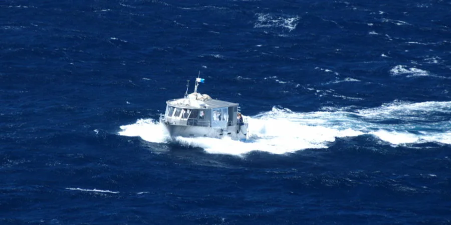 Petit bateau de plongée navigue sur une mer bleue et agitée