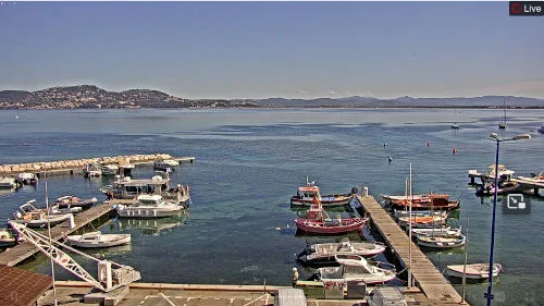 Vue d'un port avec des bateaux amarrés et des montagnes en arrière-plan