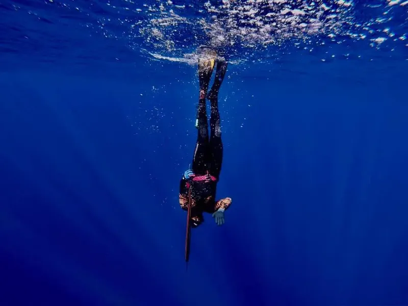Apnéiste en plongée verticale dans une eau bleue et limpide