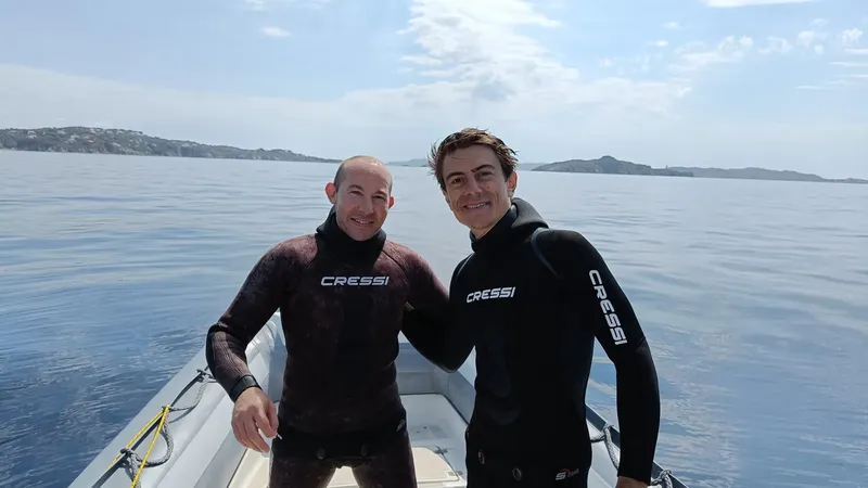 Deux hommes souriants en combinaison de plongée à bord d'un bateau