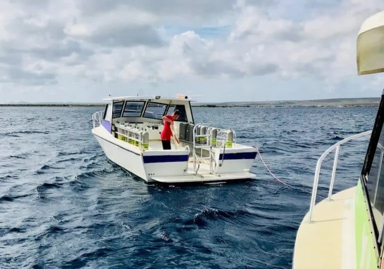 Bateau de plongée en mer avec des bouteilles et une personne à bord