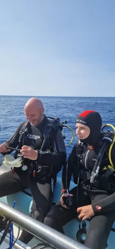 Deux plongeurs en combinaison sur un bateau en mer