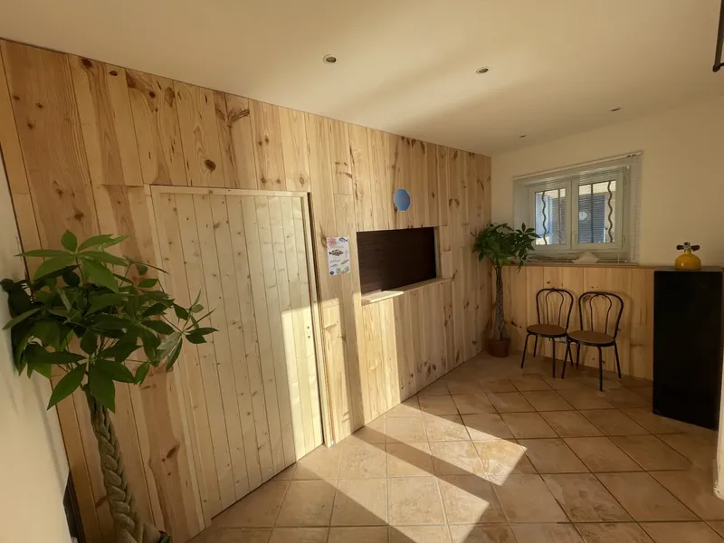 Interieur d'un local avec murs en bois, deux chaises et une fenêtre