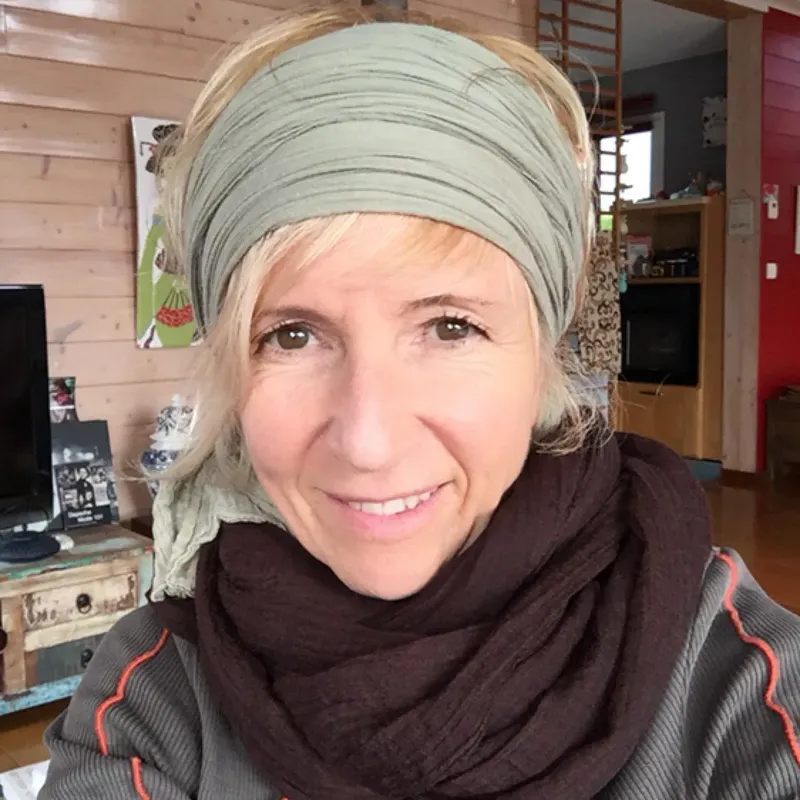 Portrait d'une femme souriante avec un bandeau et une écharpe