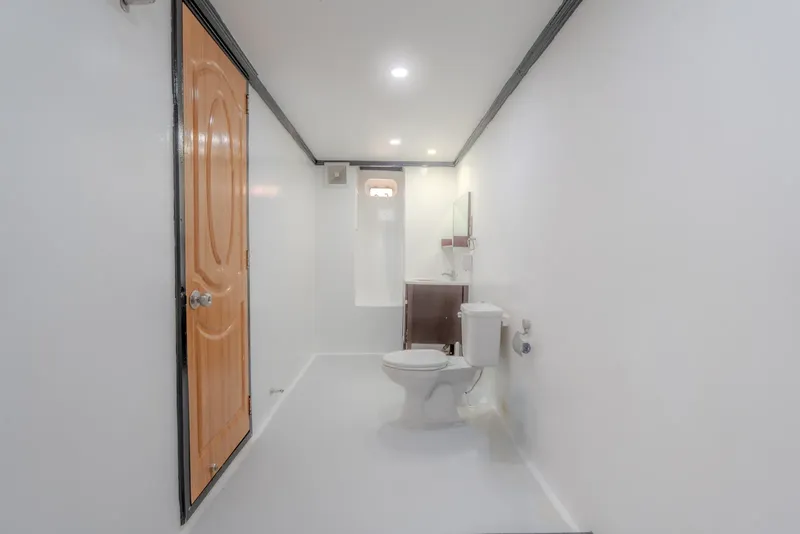 Intérieur d'un bateau avec des toilettes et une porte en bois