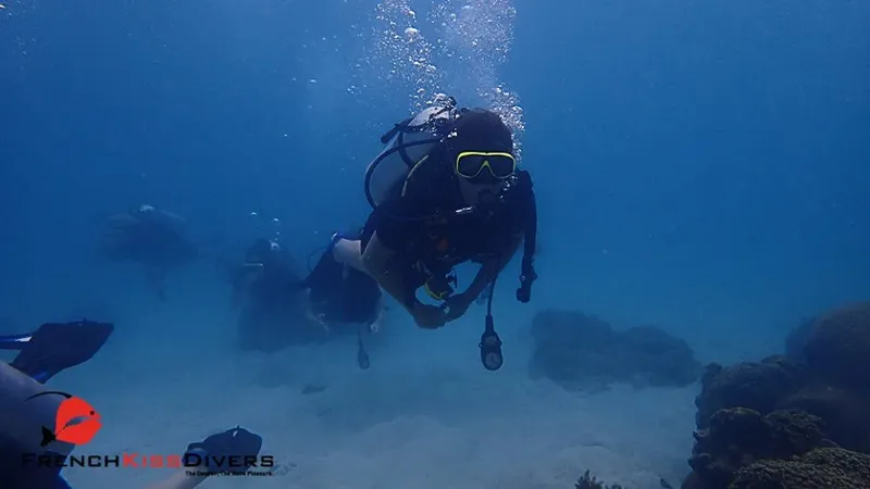 Plongeur en exploration sous-marine, équipé, nageant dans une eau claire