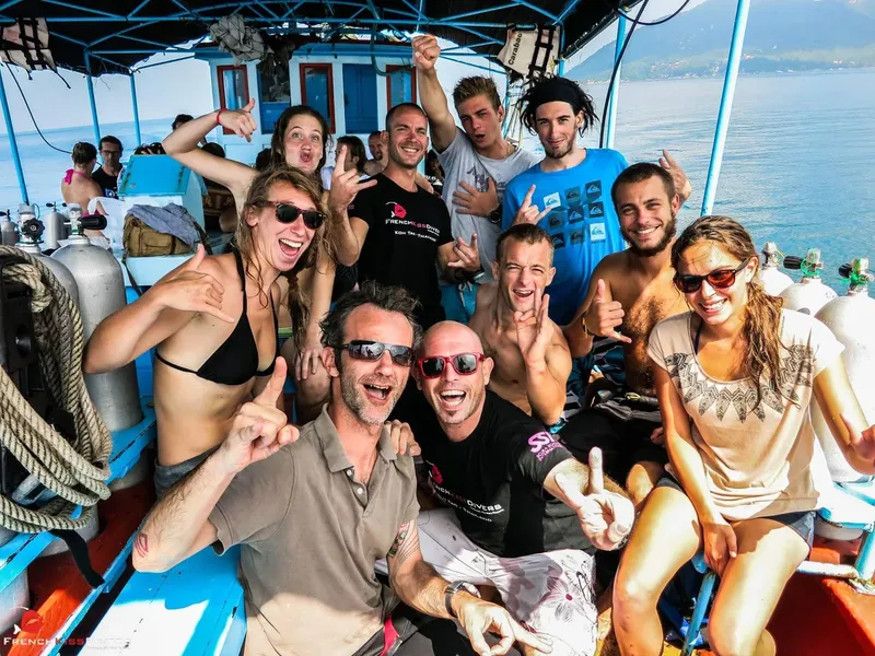 Groupe de plongeurs souriants et enthousiastes sur un bateau de plongée
