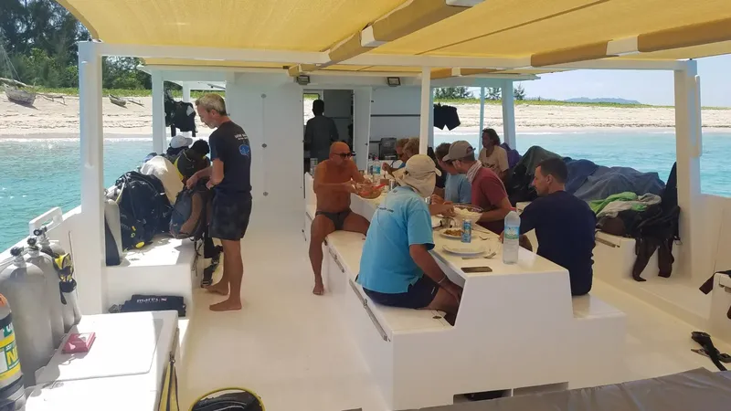 Plongée : groupe de personnes se restaure sur un bateau en mer