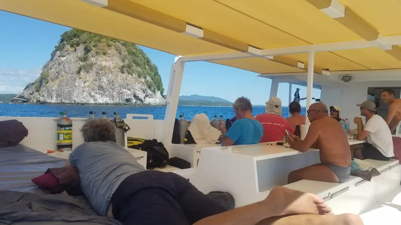 Plongée : passagers se reposent sur un bateau en direction d'une île