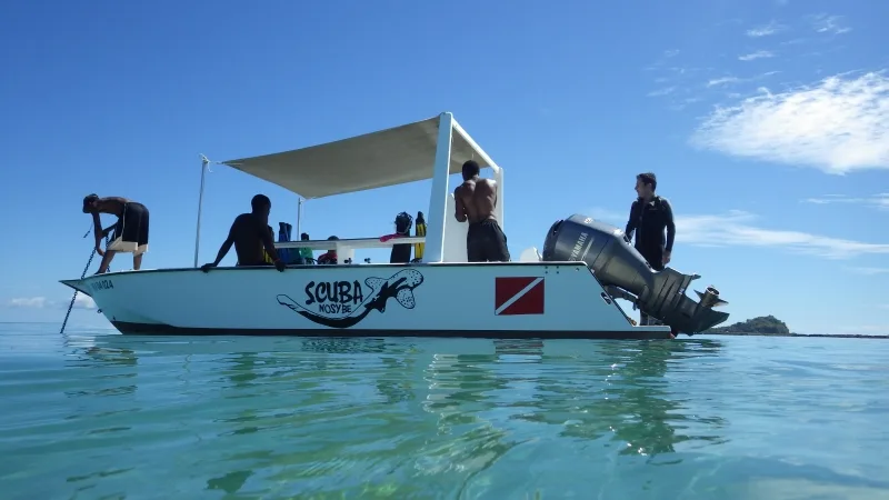 Bateau de plongée avec passagers et équipement, mer calme et ciel bleu