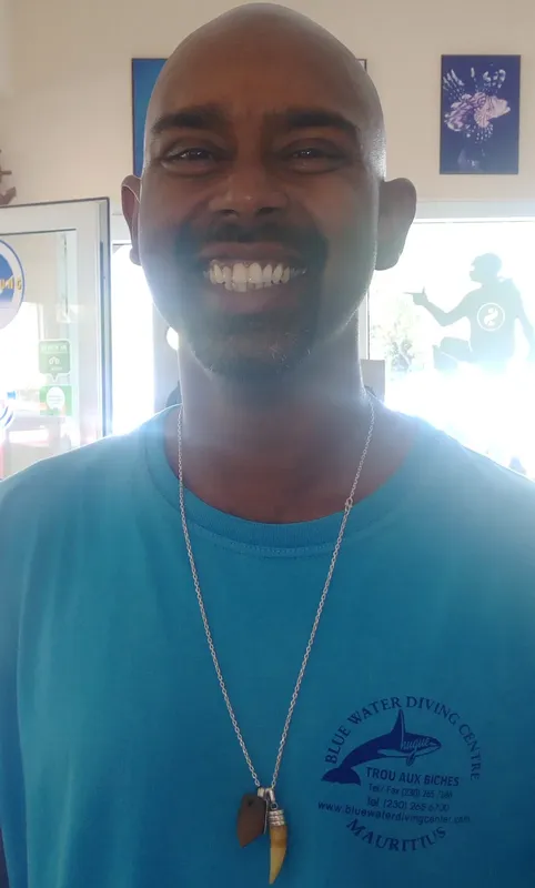 Portrait d'un homme souriant avec un pendentif et un logo de centre