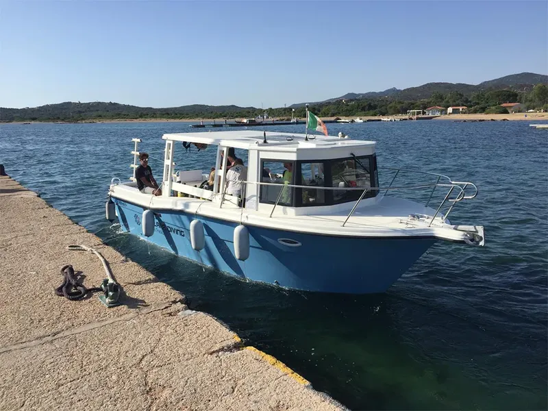 Bateau de plongée amarré à un quai avec des passagers à bord