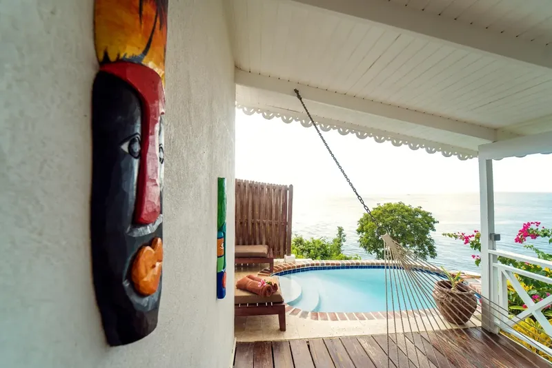 Terrasse avec piscine, hamac et vue sur la mer tropicale