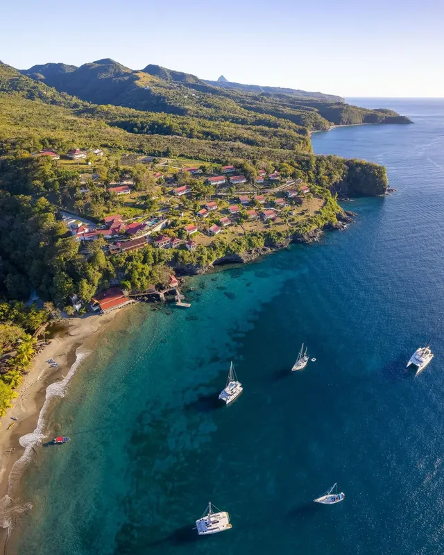 Vue aérienne d'une plage, de bâtiments et de voiliers dans une baie