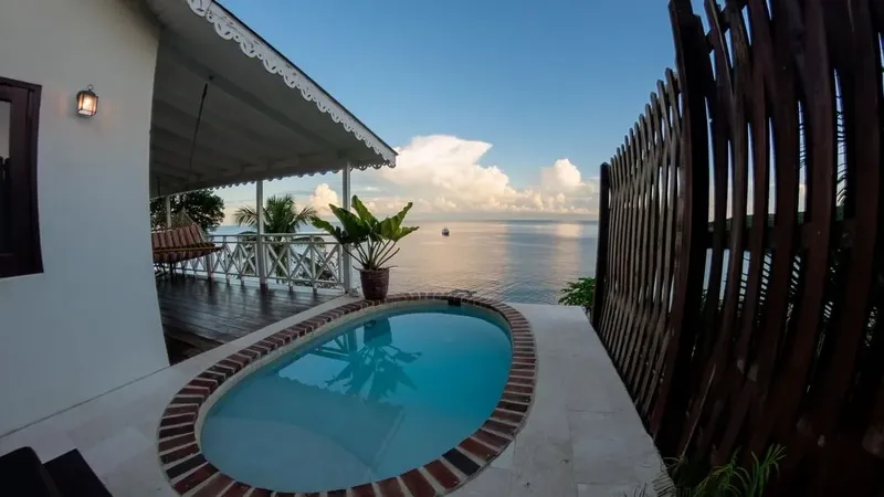 Petite piscine devant une maison blanche avec vue sur la mer