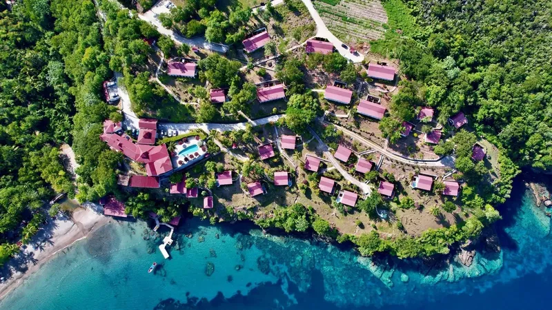 Vue aérienne d'un centre de plongée avec bâtiments, plage et mer turquoise