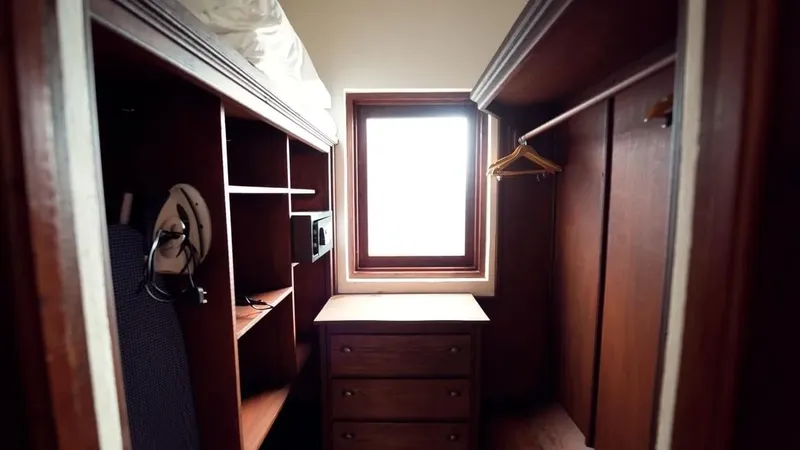 Petite chambre avec lit superposé, fenêtre et commode en bois
